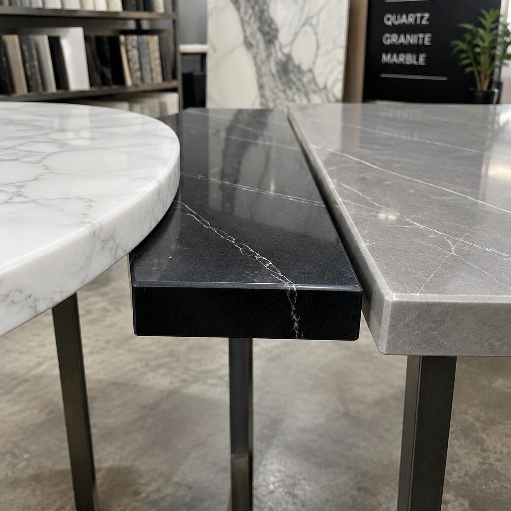 Three quartz table tops in white, black and grey showing polished edges